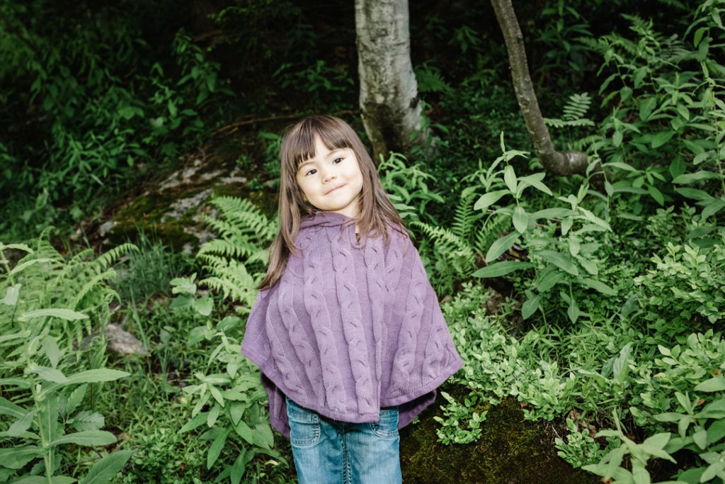 Une petite fille se trouve dans une forêt de montagne à la végétation luxuriante. Printemps 2018, Chamonix, France.