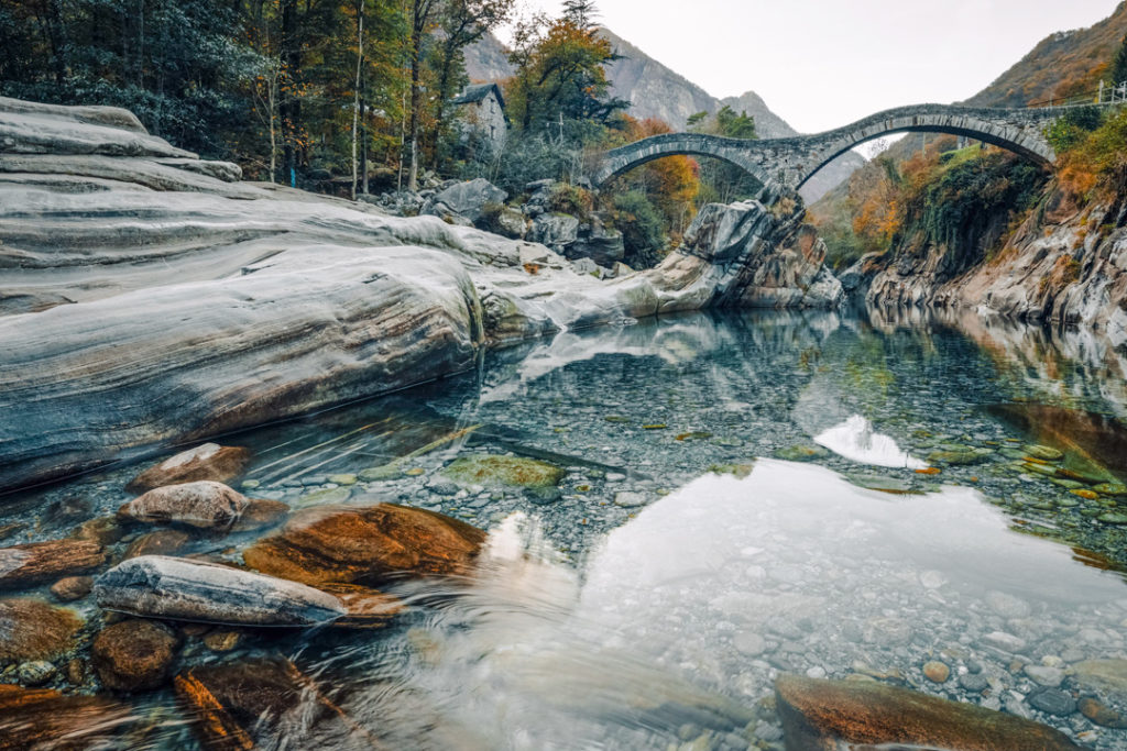 Ponte dei Salti, a remarkable stone bridge over the crystal-clear waters of the Verzasca valley, Ticino, Switzerland, Autumn 2018.