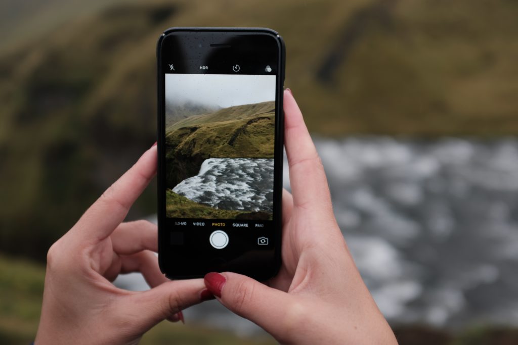 Une femme tient un smartphone et va prendre une photo