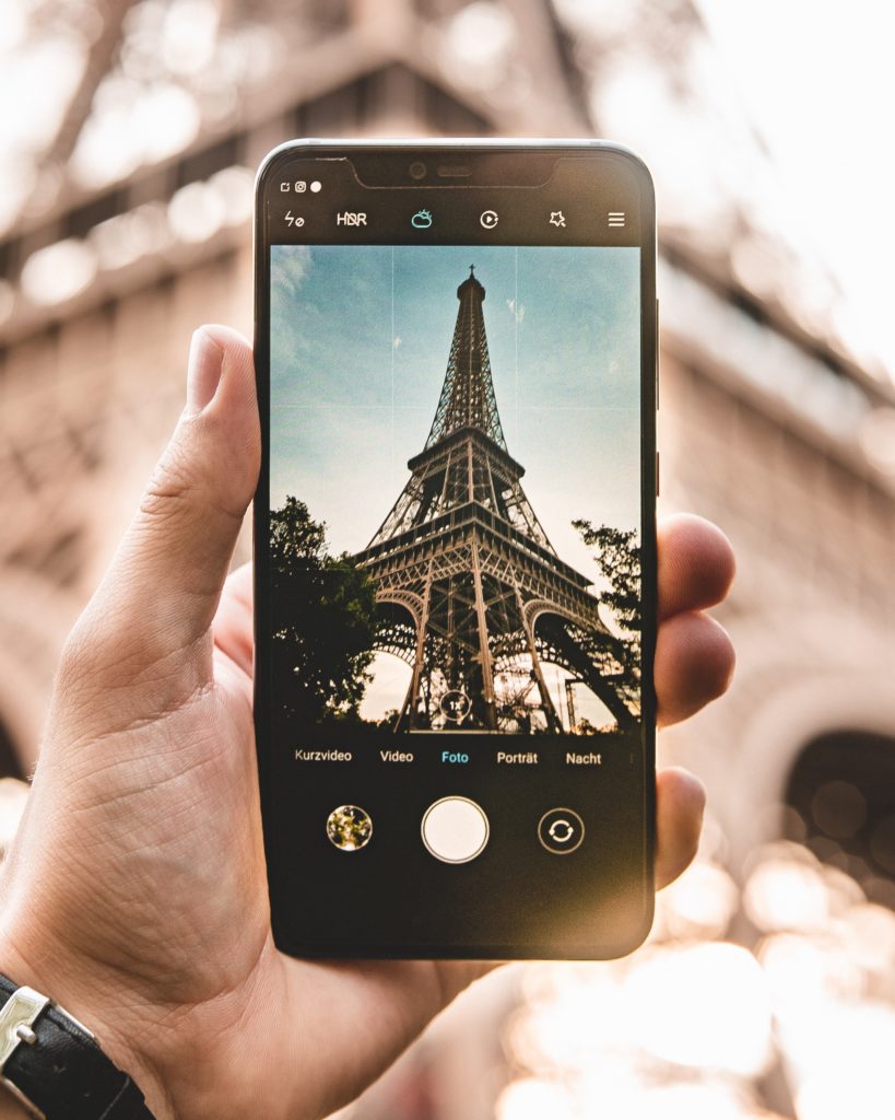 Someone taking a photo of the Eiffel Tower with their smartphone.