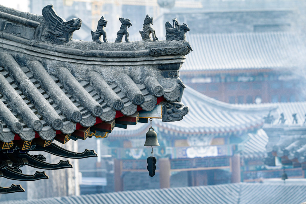 Mythical figures and ornate timberwork in a traditional temple in Tianjin.
