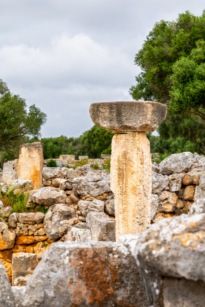 Colonne talayotique vue de près, fût de calcaire surmonté d'une dalle contre un ciel nuageux, Torre d'en Galmés, Minorque