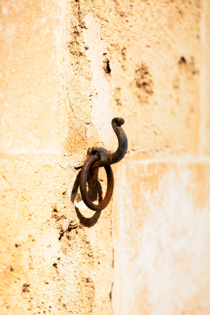 Anneau d'amarrage en fer forgé scellé dans un mur de calcaire doré, Ciutadella, Minorque